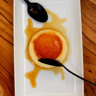 flan on plate with 2 spoons