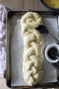 challah being brushed with egg wash