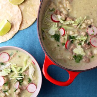 soup in a pot next to a bowl of soup with tortillas