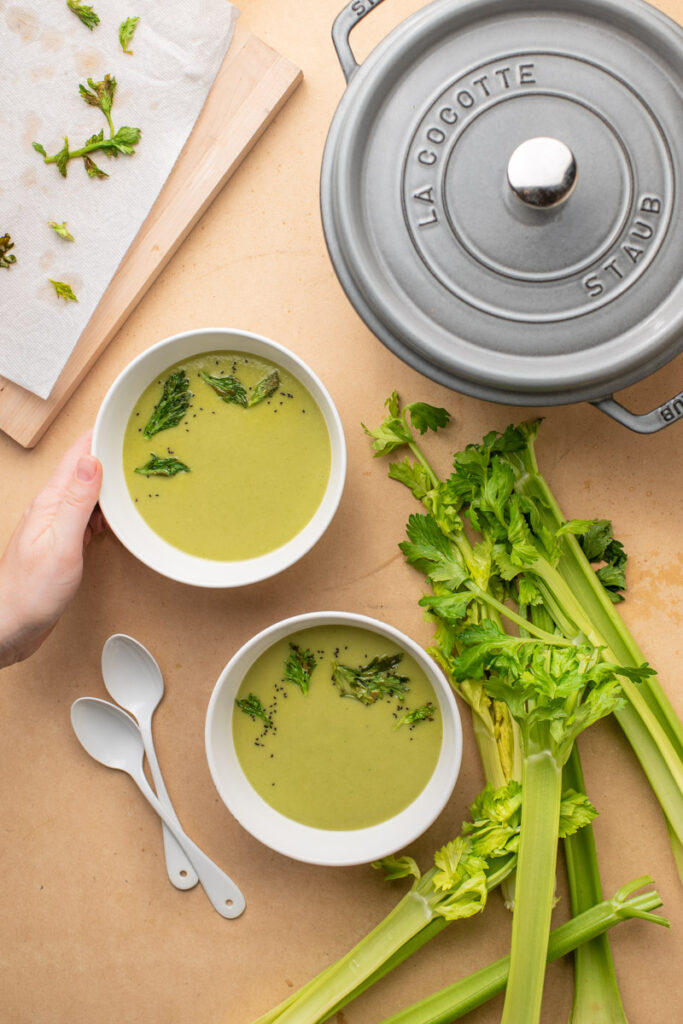 celery soup with fresh celery stalks and leaves
