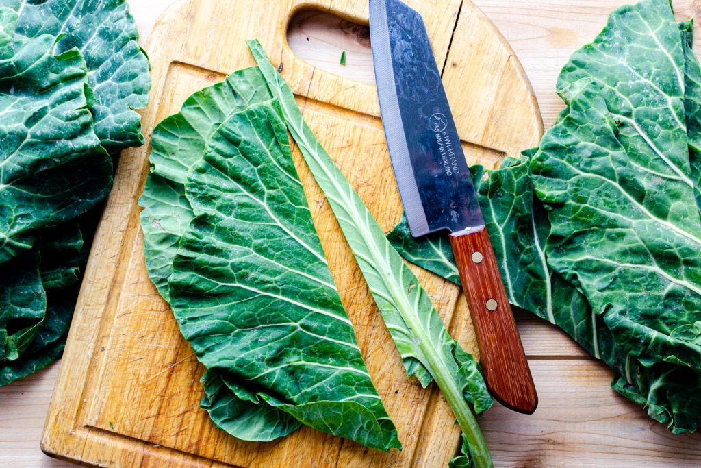 removing a collard green leaf stem with a chef's knife