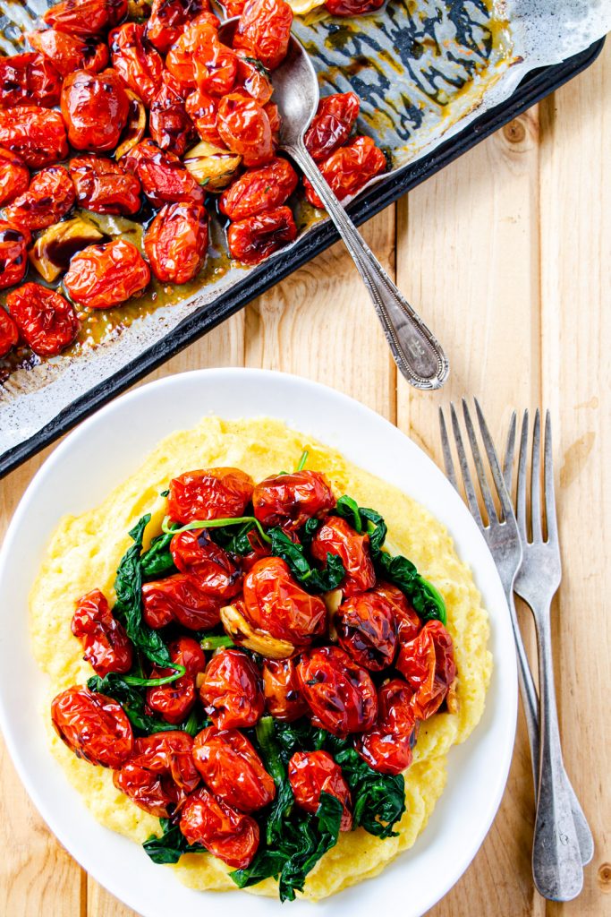 grits served with roasted cherry tomato sauce and greens