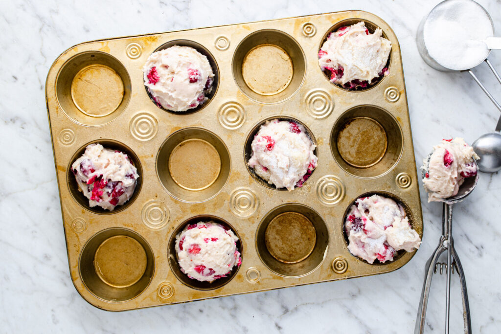 fresh cranberry muffin batter in muffin tray