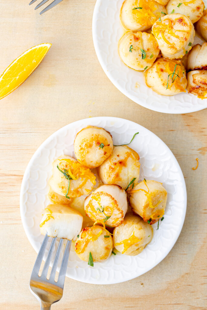 jumbo sea scallops plated with orange zest and tarragon