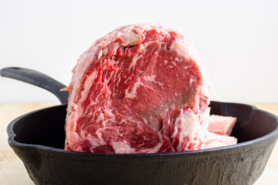 side view of a prime rib roast in cast iron pan