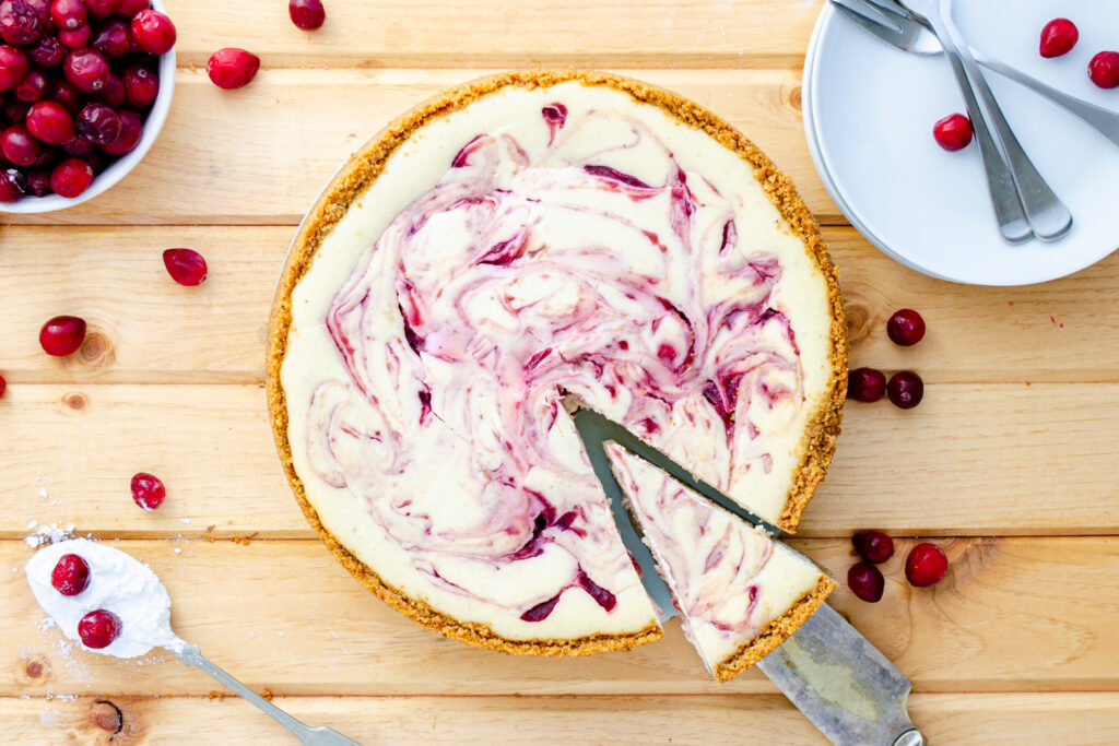 a classic perfect cheesecake with cranberry sauce swirls