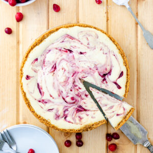 Cheesecake with fresh cranberry sauce swirls on top