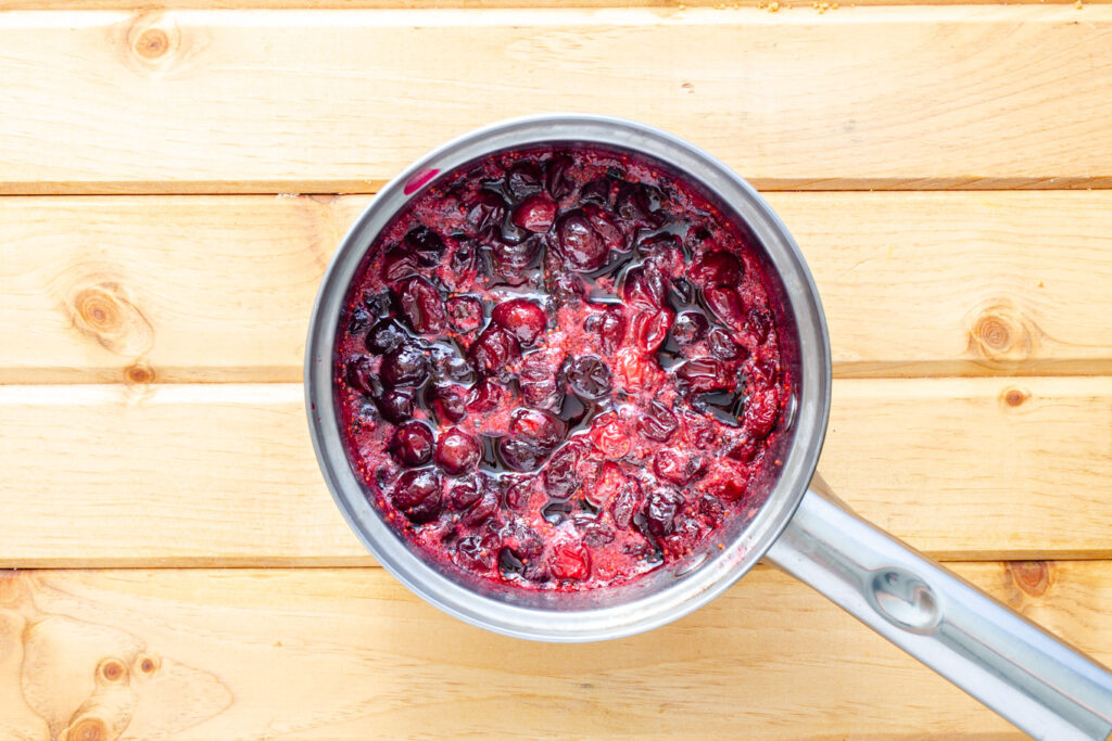 simmering cranberries with sugar and water and raspberry liqueur