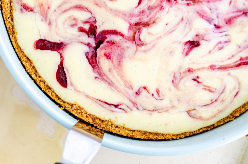 cheesecake crust being pried away from springform pan with offset spatula