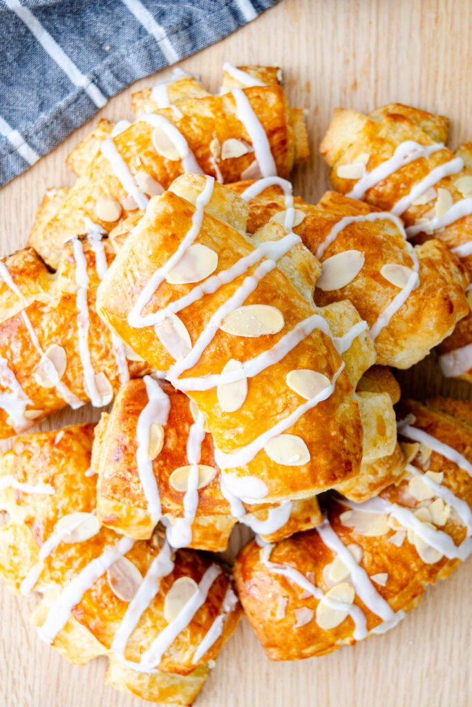 almond bear claw pastries topped with icing and slivered almonds