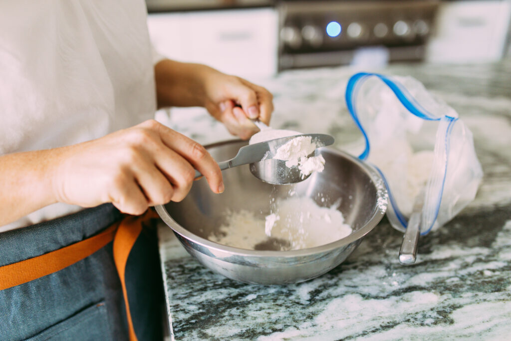 leveling flour in measuring cup with knife
