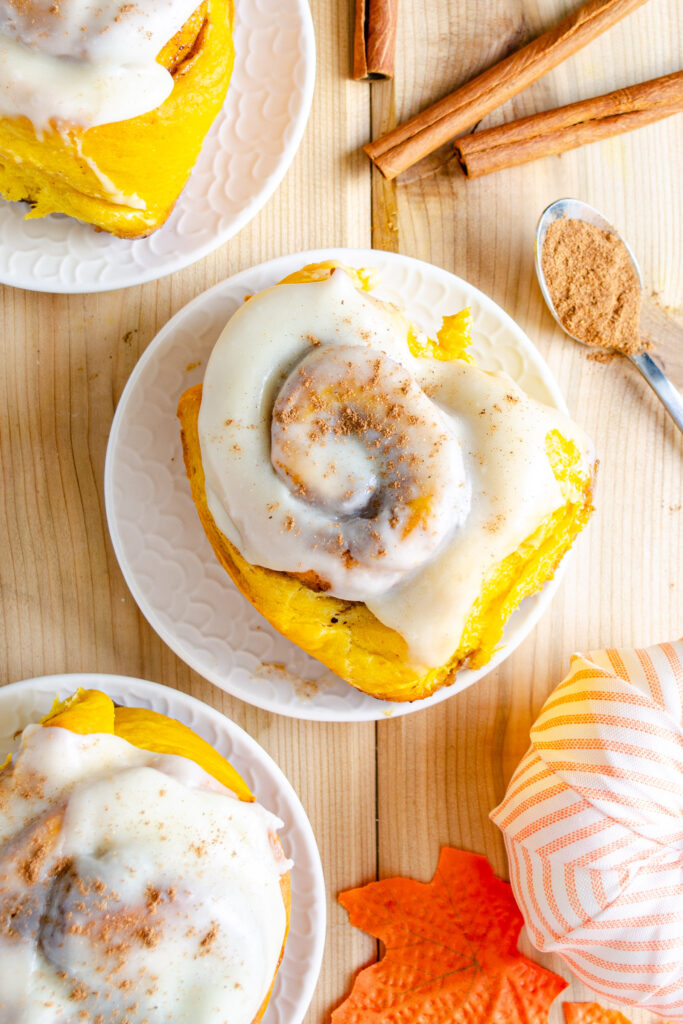 pumpkin cinnamon bun on plate with pumpkin pie spice