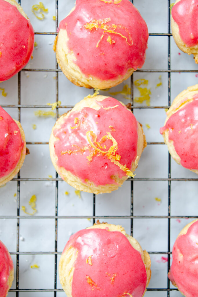 lemon cookies glazed with lemon icing on cooling rack with lemon zest