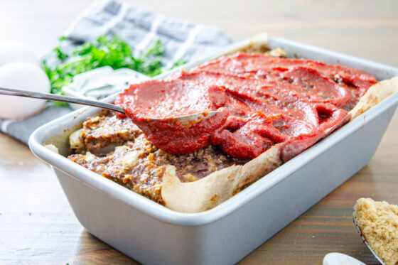 adding tomato paste topping to meatloaf