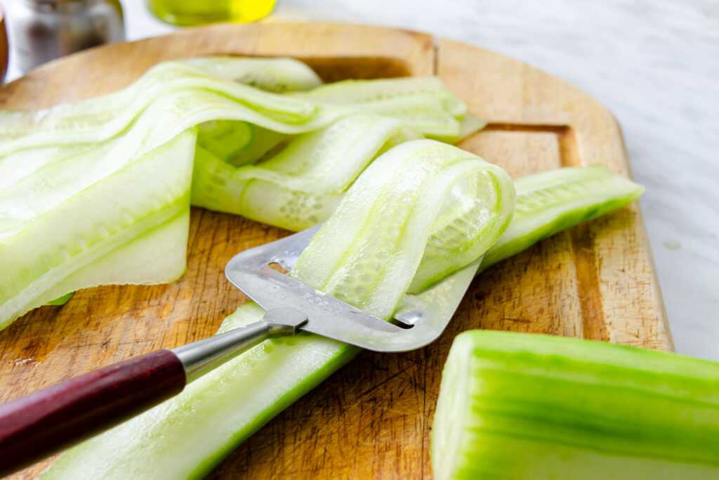 peeling thin strips of cucumber