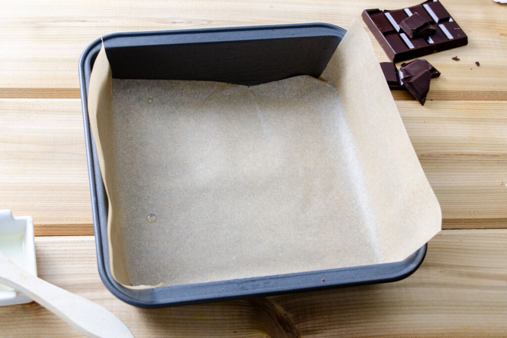 8 by 8 inch square brownie baking pan lined with parchment paper