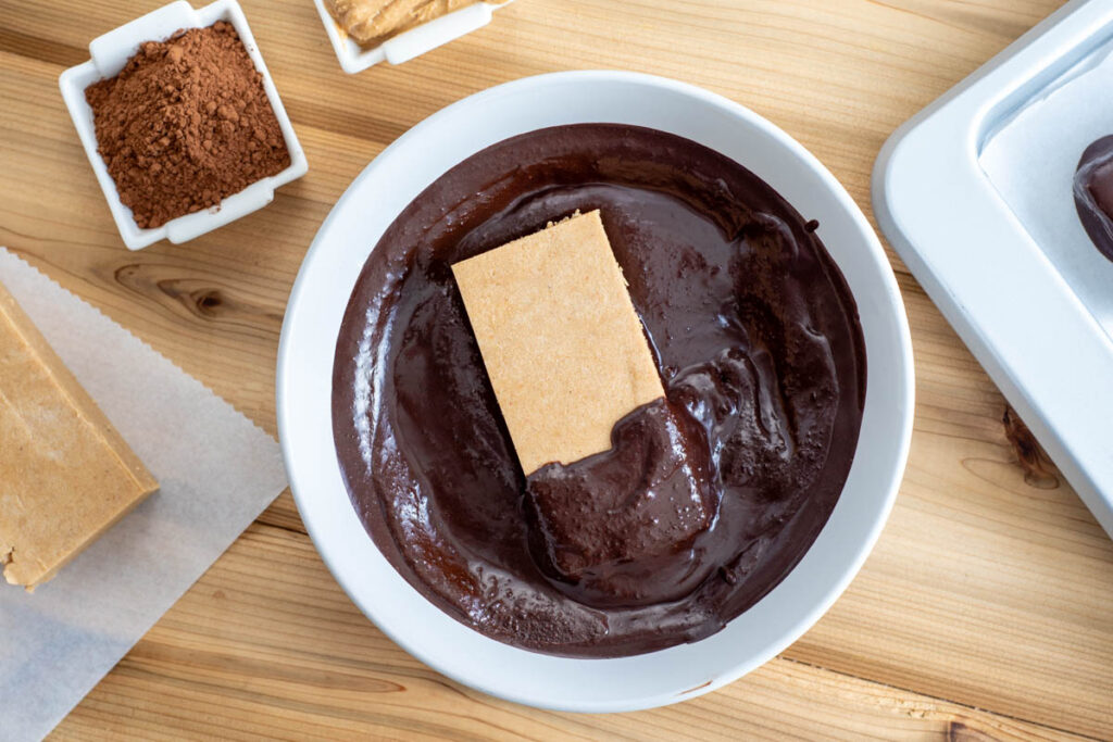 protein bar sitting in melted chocolate